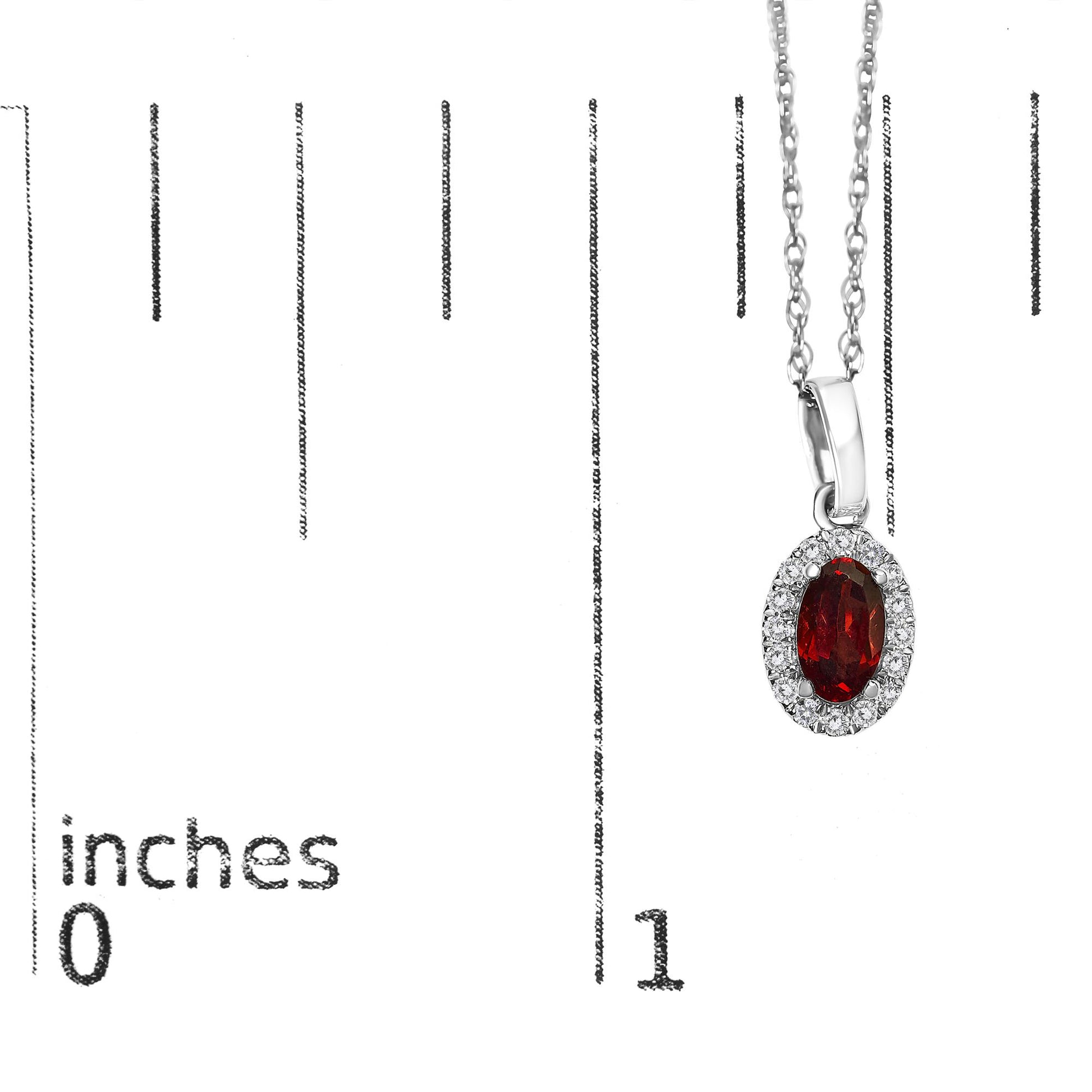 Close-up front angle of a white metal necklace with an oval red gemstone pendant surrounded by small round white gemstones, displayed on a ruler for size reference.