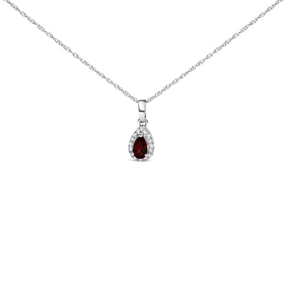 Front view of a white metal necklace featuring a pear-shaped red gemstone pendant surrounded by a halo of small round white gemstones in a micro-pave setting.