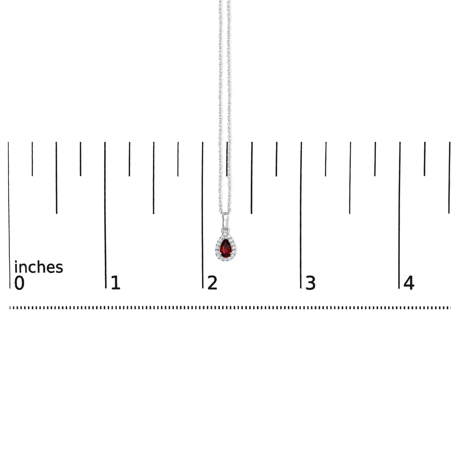White metal necklace with a pear-shaped red gemstone pendant surrounded by round white gemstones, shown hanging vertically over a ruler for size reference.