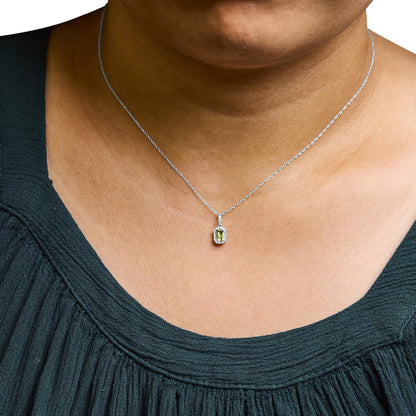 White necklace with a yellow emerald-shaped gemstone pendant surrounded by small round white gemstones, worn on a model, front angle.