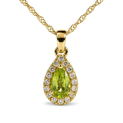 Close-up front view of a yellow necklace with a pear-shaped green gemstone surrounded by round white gemstones set in a pendant on a woven chain.