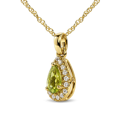 Close-up front view of a yellow metal necklace with a pear-shaped green gemstone pendant surrounded by round white gemstones in prong settings.