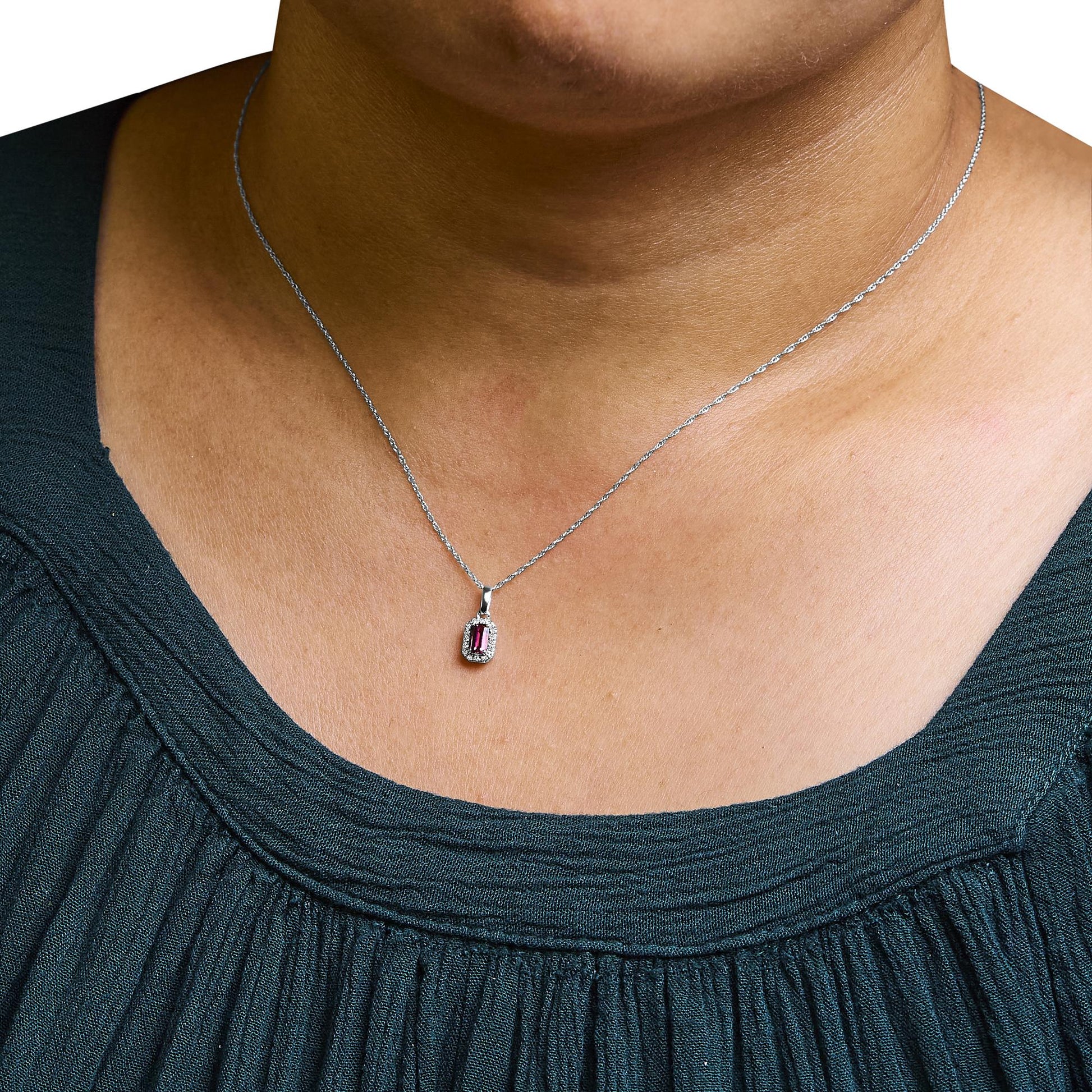 White metal necklace with a rectangular pink gemstone pendant surrounded by small white gemstones, worn on a model, front close-up angle.