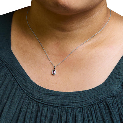 White metal necklace with a rectangular pink gemstone pendant surrounded by small white gemstones, worn on a model, front close-up angle.