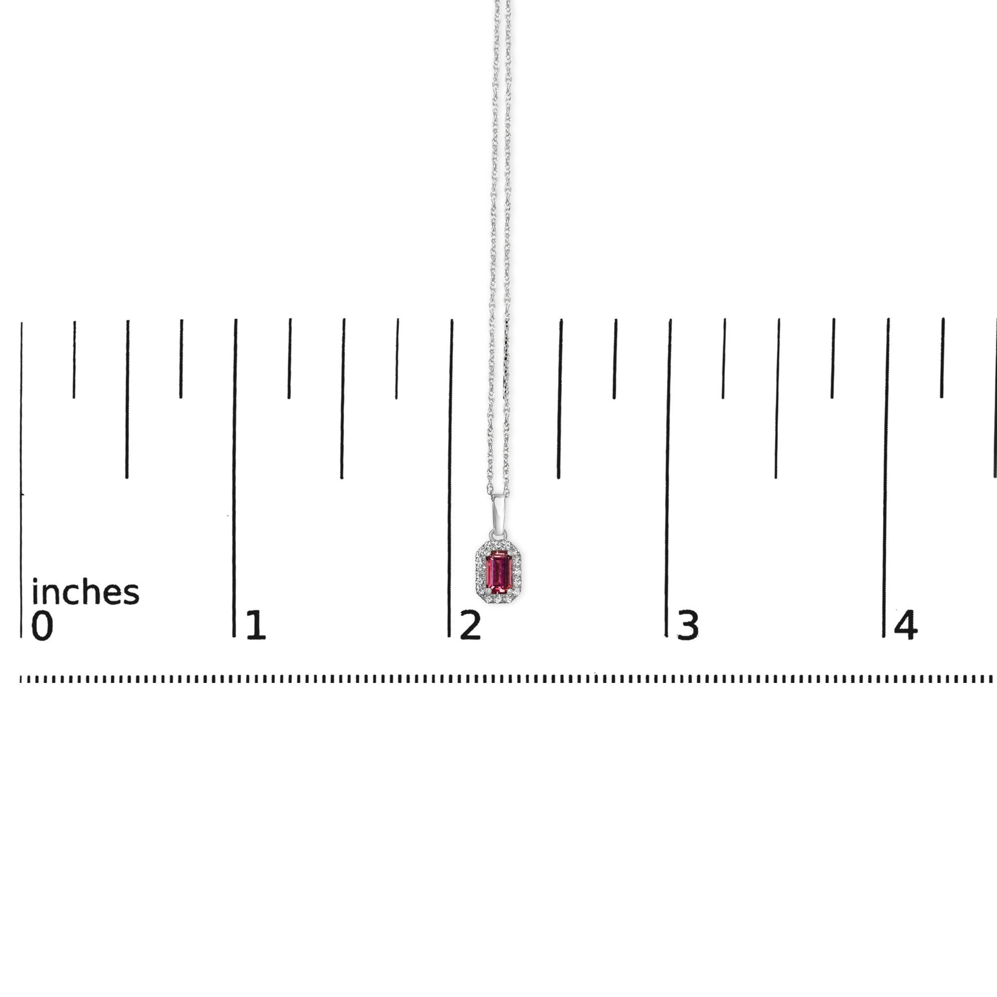 White necklace with a pink oval gemstone surrounded by small white round gemstones, shown on a ruler for size reference, front view.