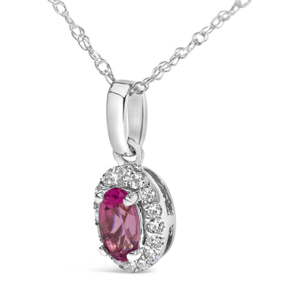 Close-up front angled shot of a white necklace pendant featuring a pink pear-shaped gemstone surrounded by a halo of round white gemstones in a micro-pave setting.
