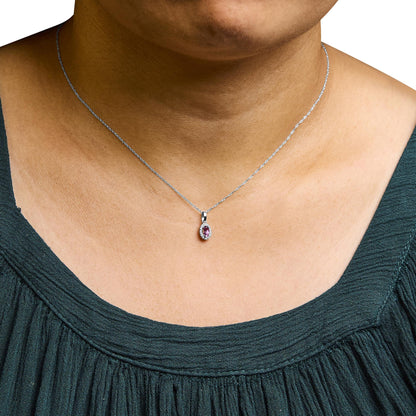 Close-up front view of a white necklace on a model, featuring a pear-shaped pink gemstone pendant surrounded by small round white gemstones in a micro-pave setting.