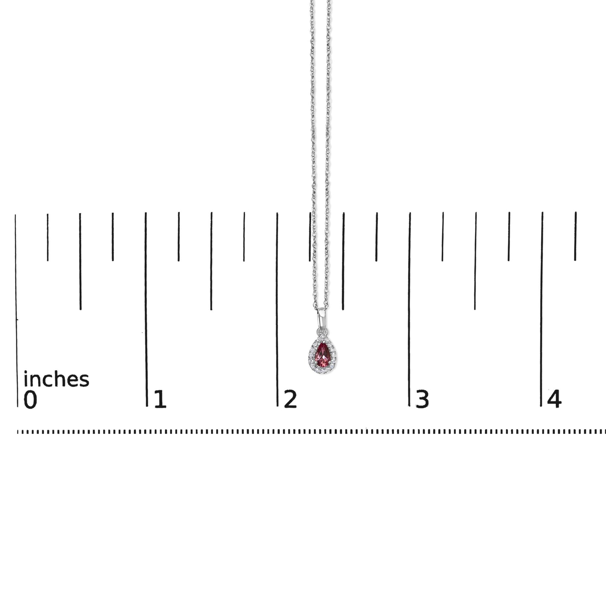 White metal necklace with a pear-shaped pink gemstone pendant surrounded by small round white gemstones in a micro-pave setting, shown hanging against a ruler for size reference, front-facing angle.