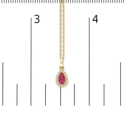 Close-up front view of a yellow metal necklace with a pear-shaped pink gemstone pendant surrounded by small round white gemstones, shown on a scale.