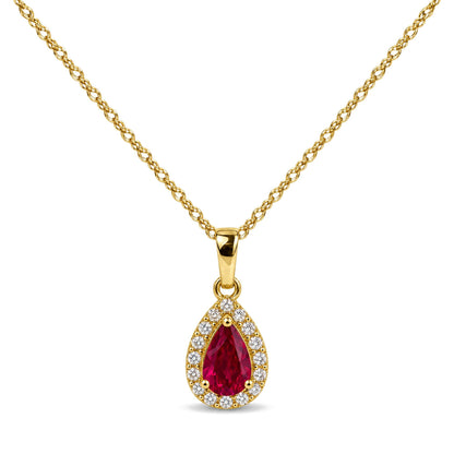 Close-up front view of a yellow metal necklace with a pear-shaped red gemstone pendant surrounded by small white gemstones in prong settings.