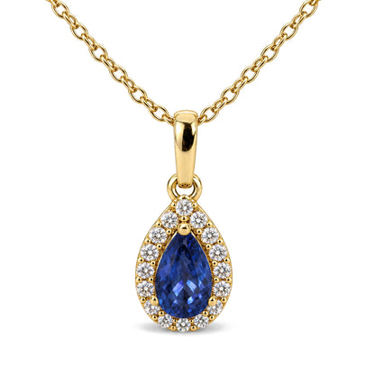 Close-up front view of a yellow necklace featuring a pear-shaped blue gemstone pendant surrounded by small round white gemstones in prong settings.