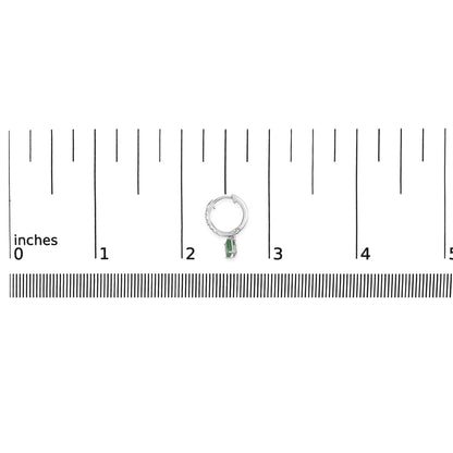White metal hoop earring with pave-set white round gemstones on the front, featuring a dangling green emerald-shaped gemstone in a prong setting, shown on a ruler scale from a top-down angle.