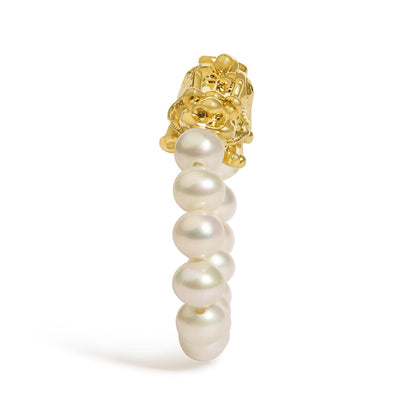 Close-up front view of a yellow metal ring with an intricate floral design and a row of white round gemstones, shown on a white background.