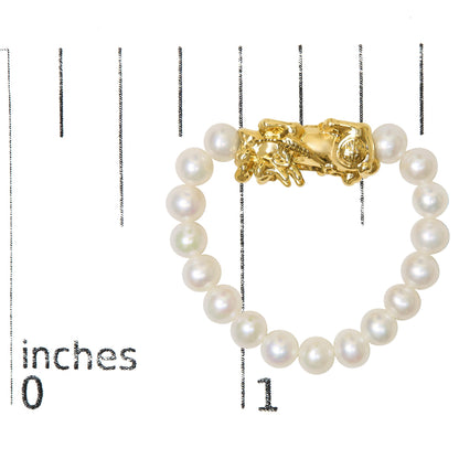 Yellow metal ring with irregular shaped design and surrounding white gemstones, shown on a scale, top view.