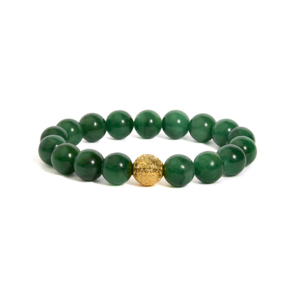 Close-up front angle of a bracelet composed of round green gemstones with a single intricate yellow metal bead in the center, shown on a white background.