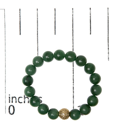 Close-up front view of a yellow metal bracelet with round green aventurine gemstones and an ornate yellow metal bead, shown on a measurement scale.