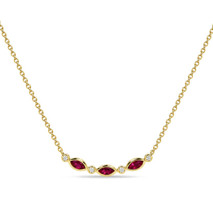 Close-up front view of a yellow metal necklace featuring alternating marquise-shaped red gemstones in prong settings and round white gemstones in bezel settings along the center.