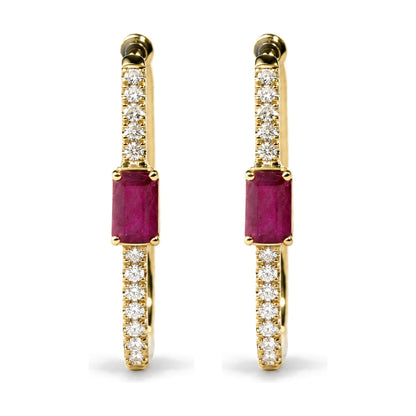 Close-up front view of a pair of yellow metal hoop earrings shown on a white background. Each earring is adorned with small round white gemstones set along the hoop and features a larger red gemstone in a prong setting at the bottom.