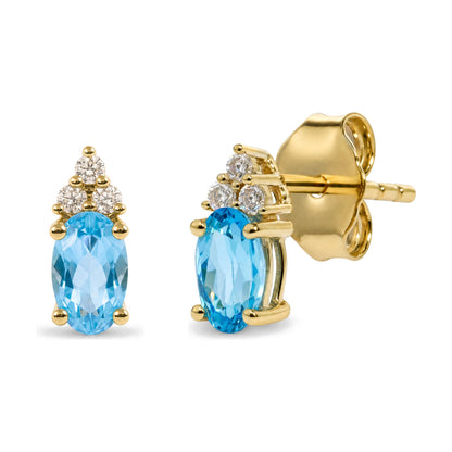 Close-up front and side view of yellow metal earrings with oval blue gemstones and round white gemstones in prong settings.