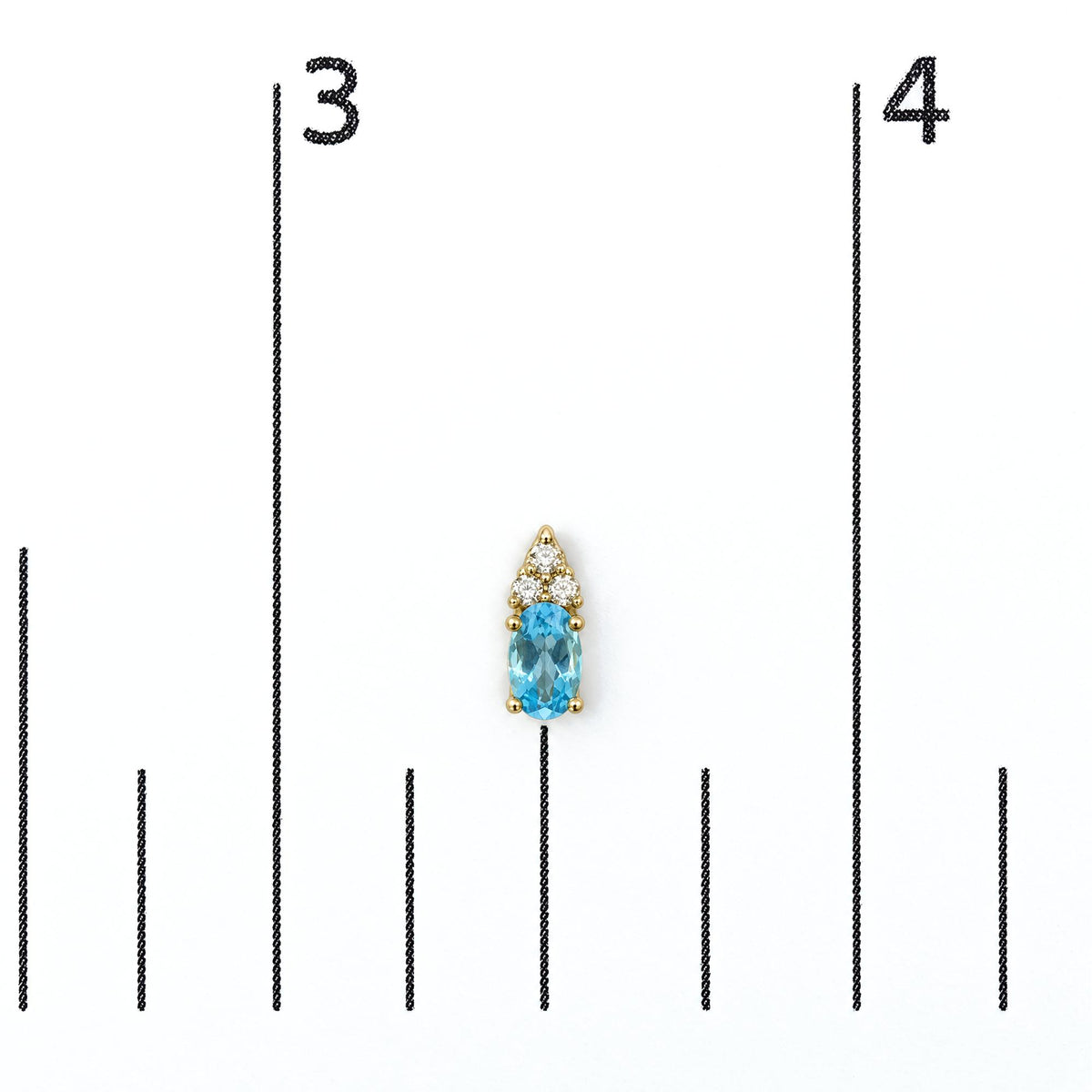 Close-up front view of a yellow metal earring with an oval blue gemstone at the bottom and a cluster of round white gemstones above, shown on a measurement scale.
