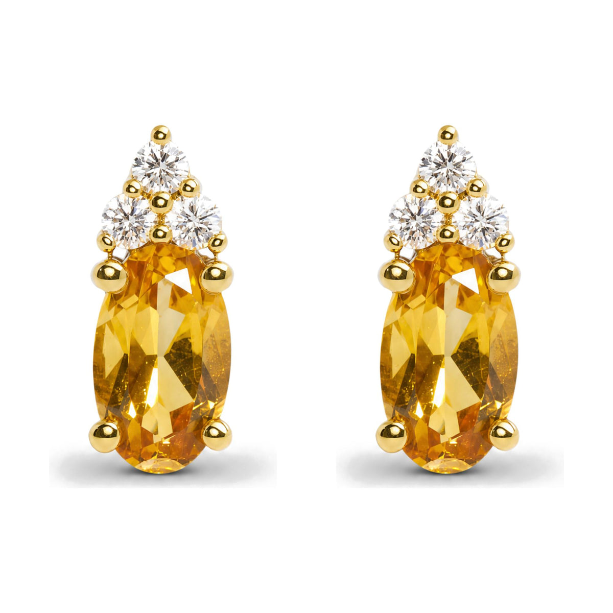 Close-up front view of yellow metal earrings with oval yellow gemstones and clusters of round white gemstones set above.