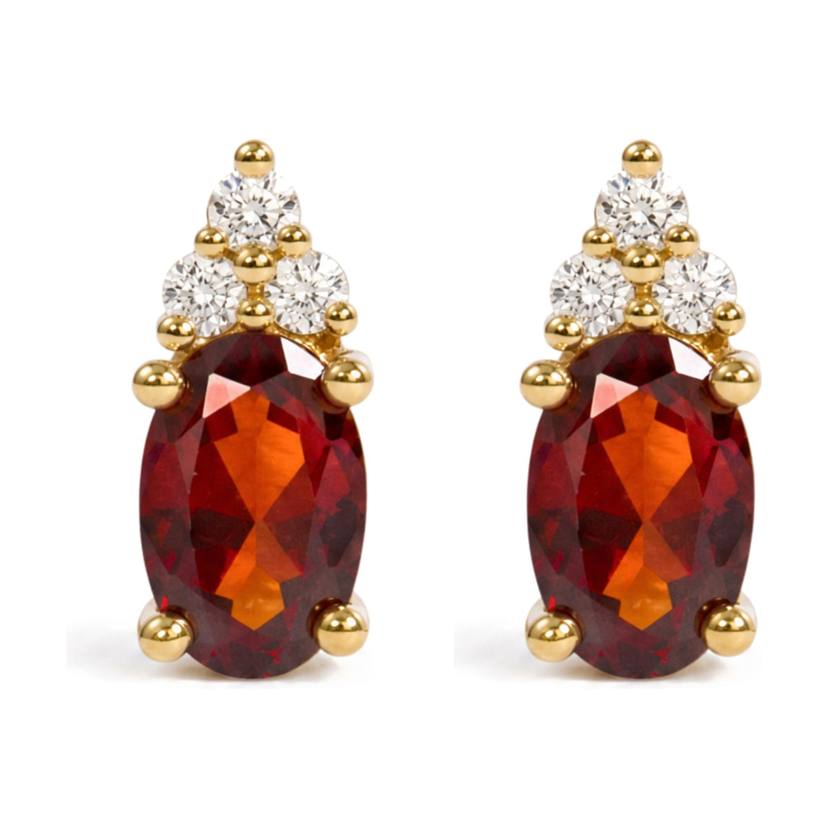 Close-up front angle of a pair of yellow metal earrings featuring an oval red gemstone in prong setting surrounded by round white gemstones in prong settings.