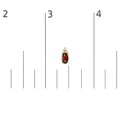 Close-up front view of a yellow metal earring with an oval red gemstone and six round white gemstones above it, shown on a measurement scale.