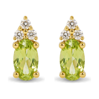Close-up front view of a pair of yellow metal earrings featuring oval green gemstones and round white gemstones in prong settings.