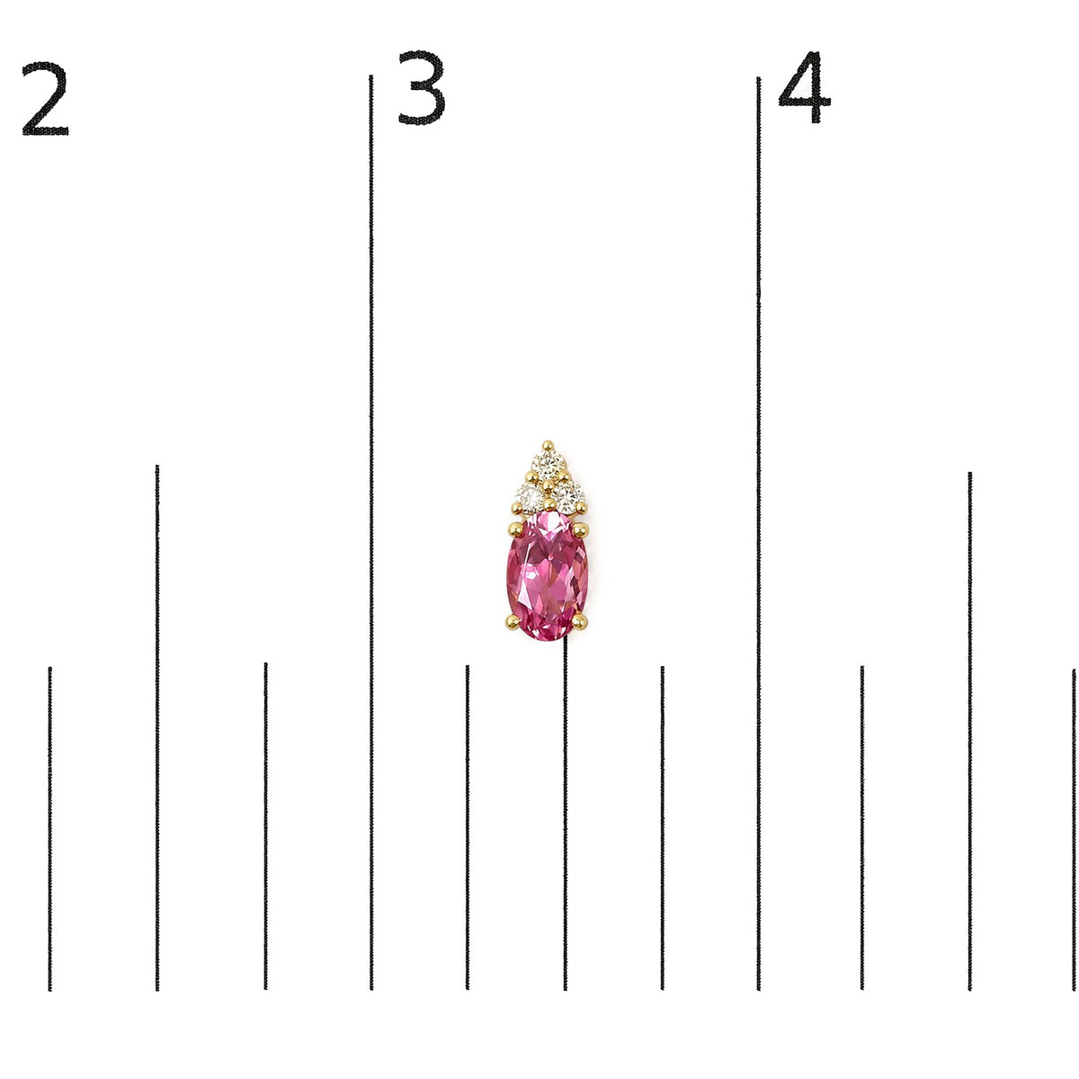 Close-up front view of a yellow metal earring featuring an oval pink gemstone below a cluster of round white gemstones, shown on a scale.