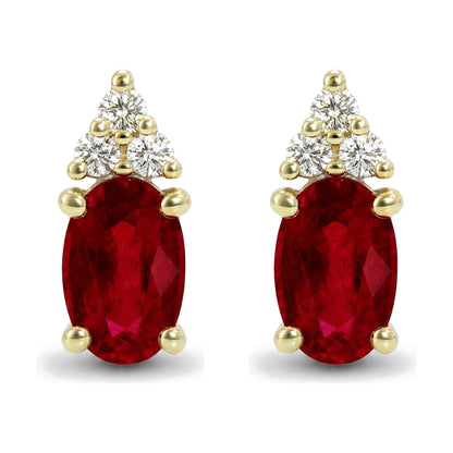 Close-up front view of a pair of yellow metal earrings featuring an oval red gemstone held by prongs, topped with a triangular cluster of round white gemstones also set in prongs.
