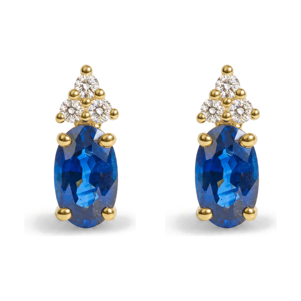 Close-up front view of a pair of yellow metal earrings featuring oval-shaped blue gemstones and clusters of round white gemstones in a prong setting.