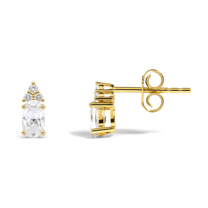 Close-up side angle of yellow metal stud earring with oval white gemstone and cluster of round white gemstones in prong settings shown on a white background.