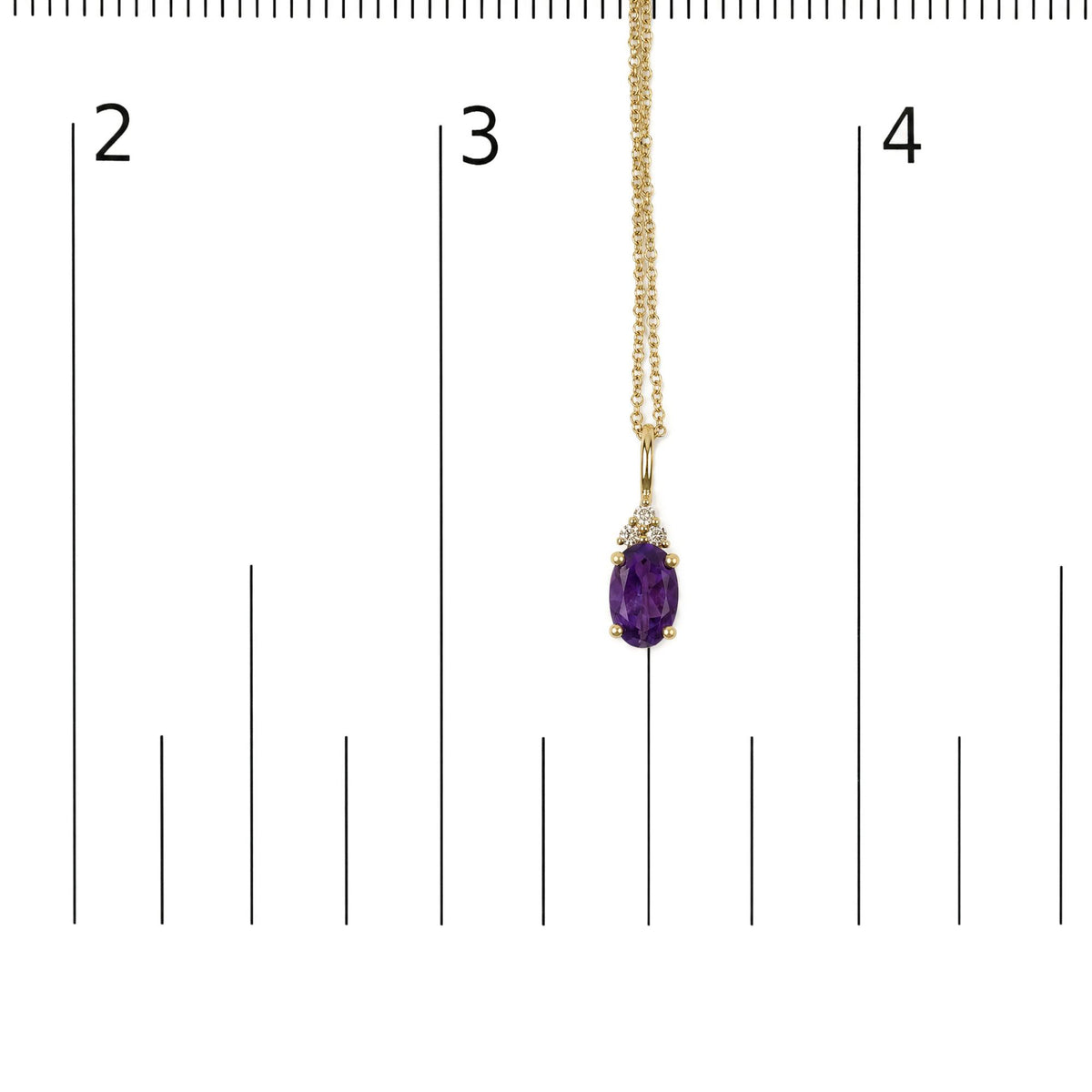 Close-up front view of a yellow necklace chain featuring a pendant with an oval purple gemstone and three small round white gemstones, shown on a scale.