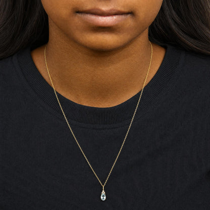 Yellow necklace with a pendant featuring an oval blue gemstone surrounded by three small round white gemstones in prong settings, shown worn on a model from the front.