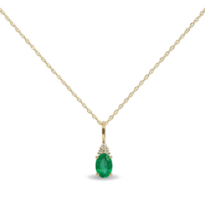 Close-up front angle of a yellow necklace with an oval green gemstone pendant surrounded by three small round white gemstones above it, shown on a white background.