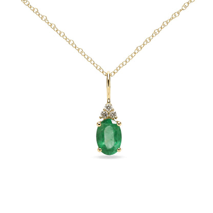 Close-up front angle of a yellow necklace chain with a pendant featuring an oval green gemstone held by prongs, accented by three round white gemstones above it in prong settings.