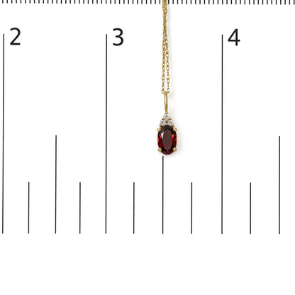 Yellow necklace with oval-shaped red gemstone pendant surrounded by three round white gemstones, shown hanging on a measurement scale, front angle.