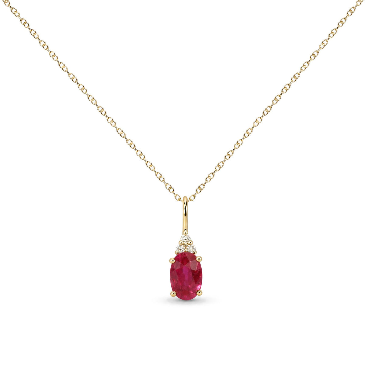 Close-up front view of a yellow metal necklace with an oval-shaped red gemstone pendant surrounded by three round white gemstones, all in prong settings.