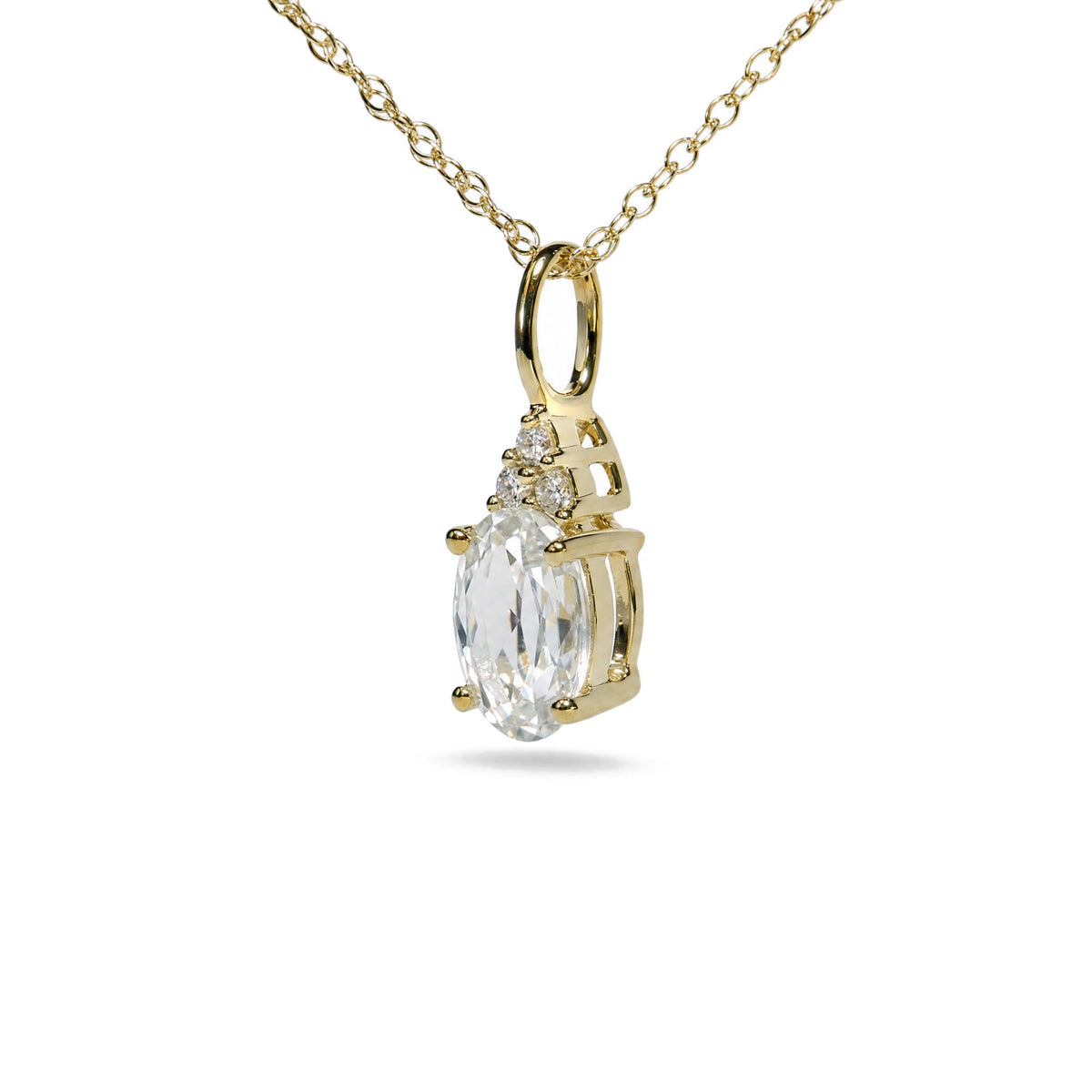 Close-up angled view of a yellow metal necklace featuring a pendant with an oval white gemstone and three round white gemstones in prong settings.