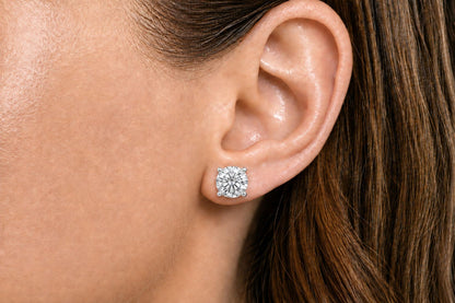 Close-up side view of a model wearing a white metal stud earring with a round white gemstone in a 4-prong setting.