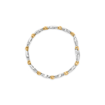 Top-down view of a two-tone bracelet with alternating yellow and white metal links, featuring white baguette-shaped gemstones in a channel setting.