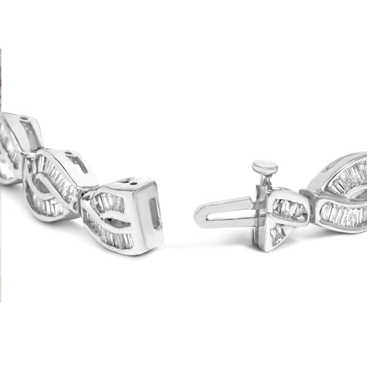 Close-up shot of a white metal bracelet with an intricate twisted design featuring baguette-shaped white gemstones set in a channel setting, showing the clasp mechanism.