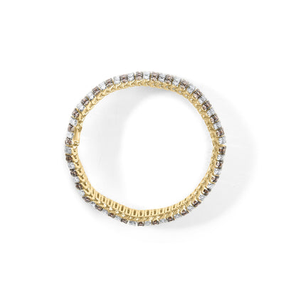 Top-down view of a yellow bracelet set with alternating prong-set round white and brown gemstones.