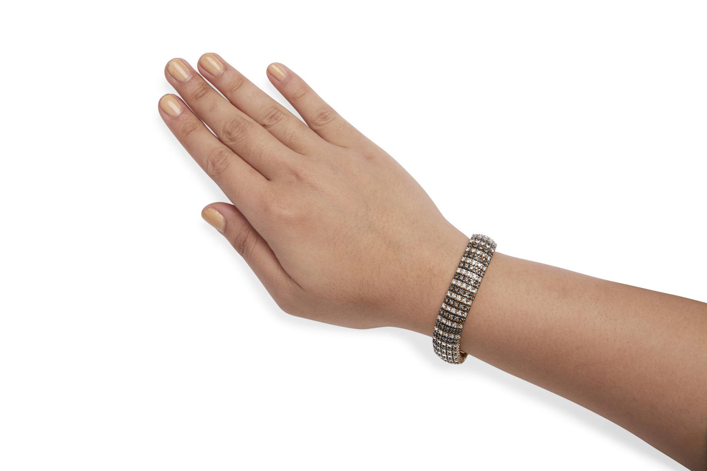 Yellow metal bracelet with alternating rows of round brown and white gemstones in prong settings, shown on a model's wrist from a top angle.