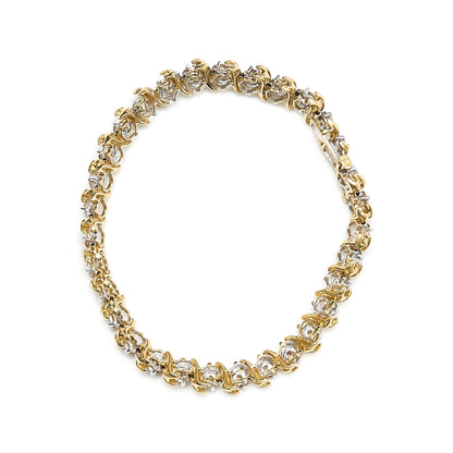 Top-down view of a yellow metal bracelet featuring round white gemstones in prong settings arranged in a continuous loop.