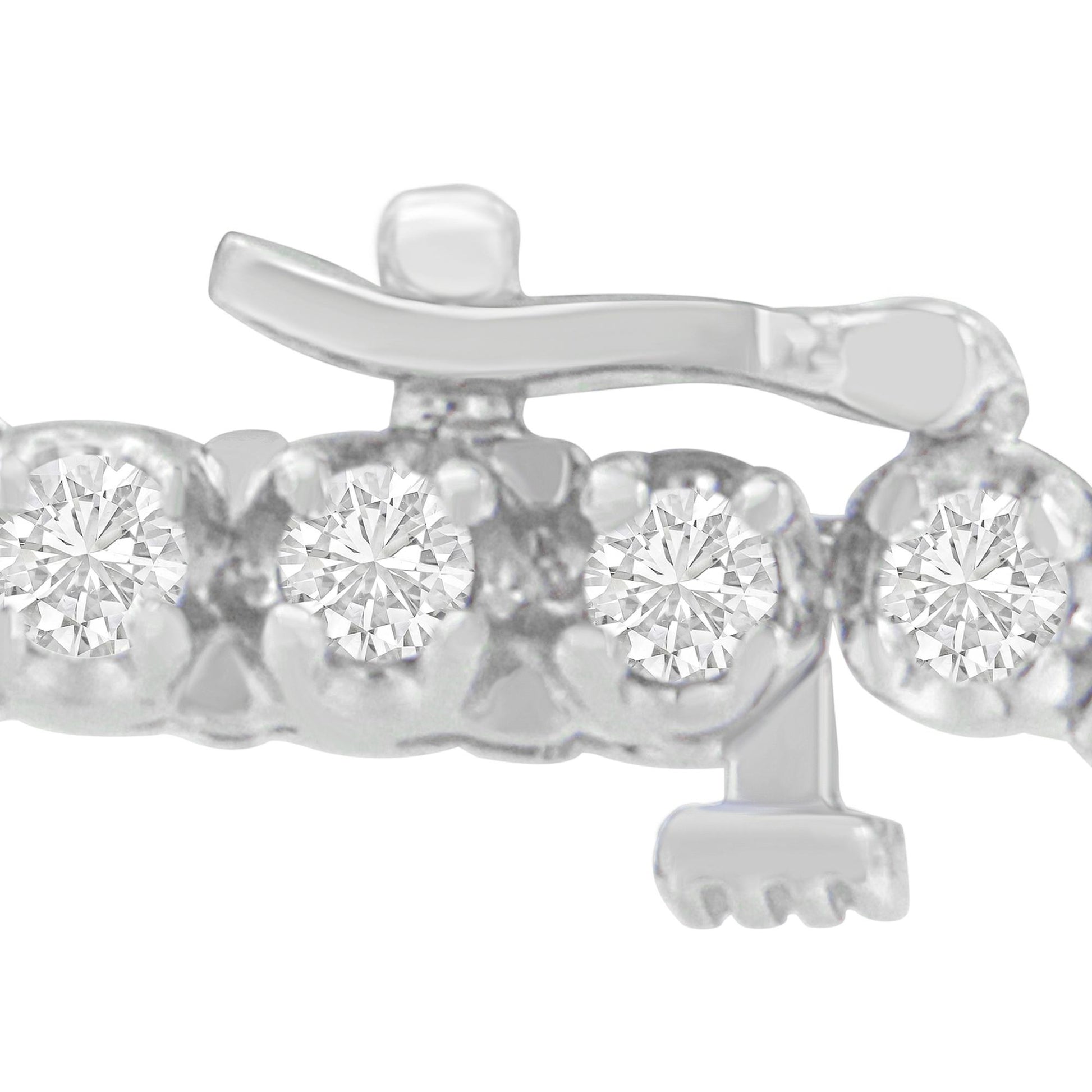 Close-up shot of a white metal bracelet clasp featuring round white gemstones in prong settings.