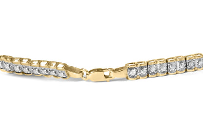 Close-up angled view of a yellow metal bracelet with round white gemstones in prong settings along the links and a clasp in the center.