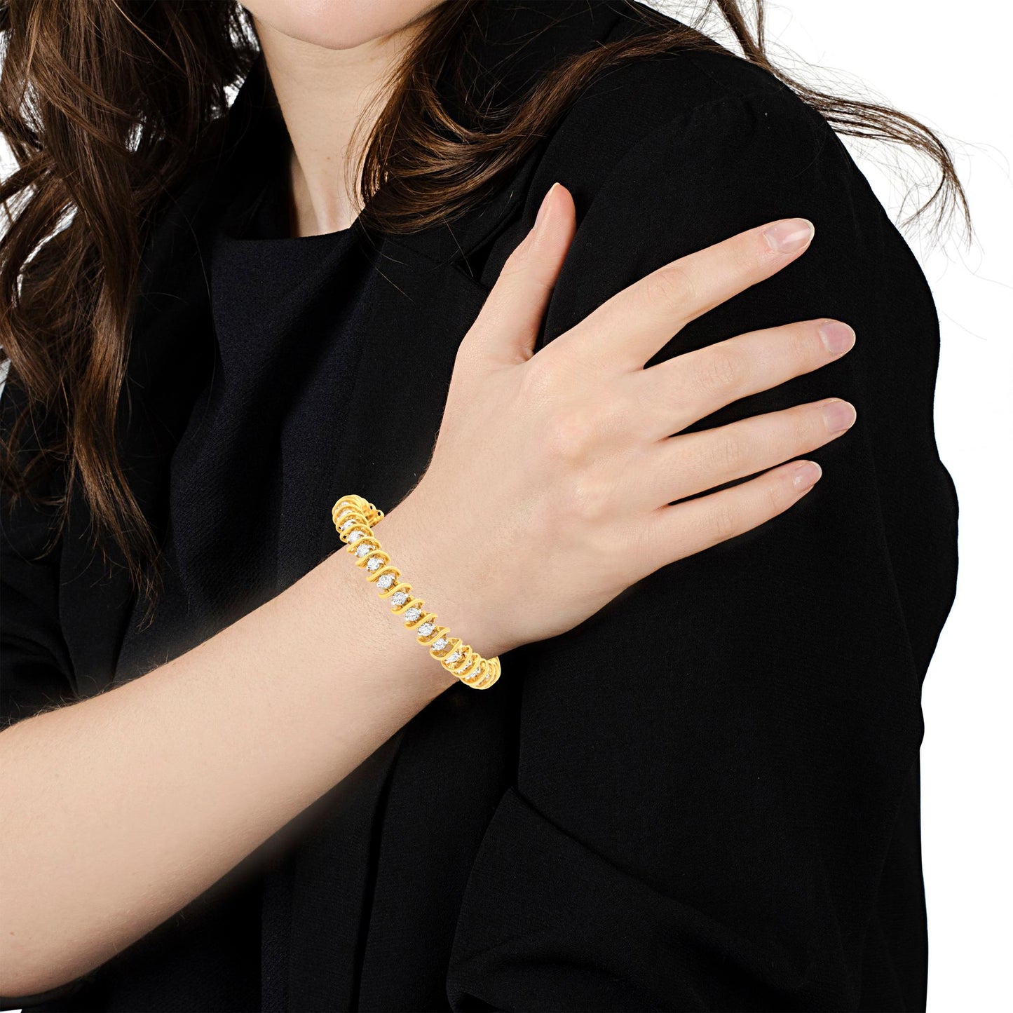 Yellow metal bracelet with round white gemstones in 2-prong settings, worn on model's wrist, angled view.