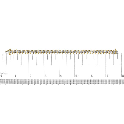 Yellow metal bracelet with round white gemstones in two-prong settings, laid flat on a ruler for size reference, top-down angle.