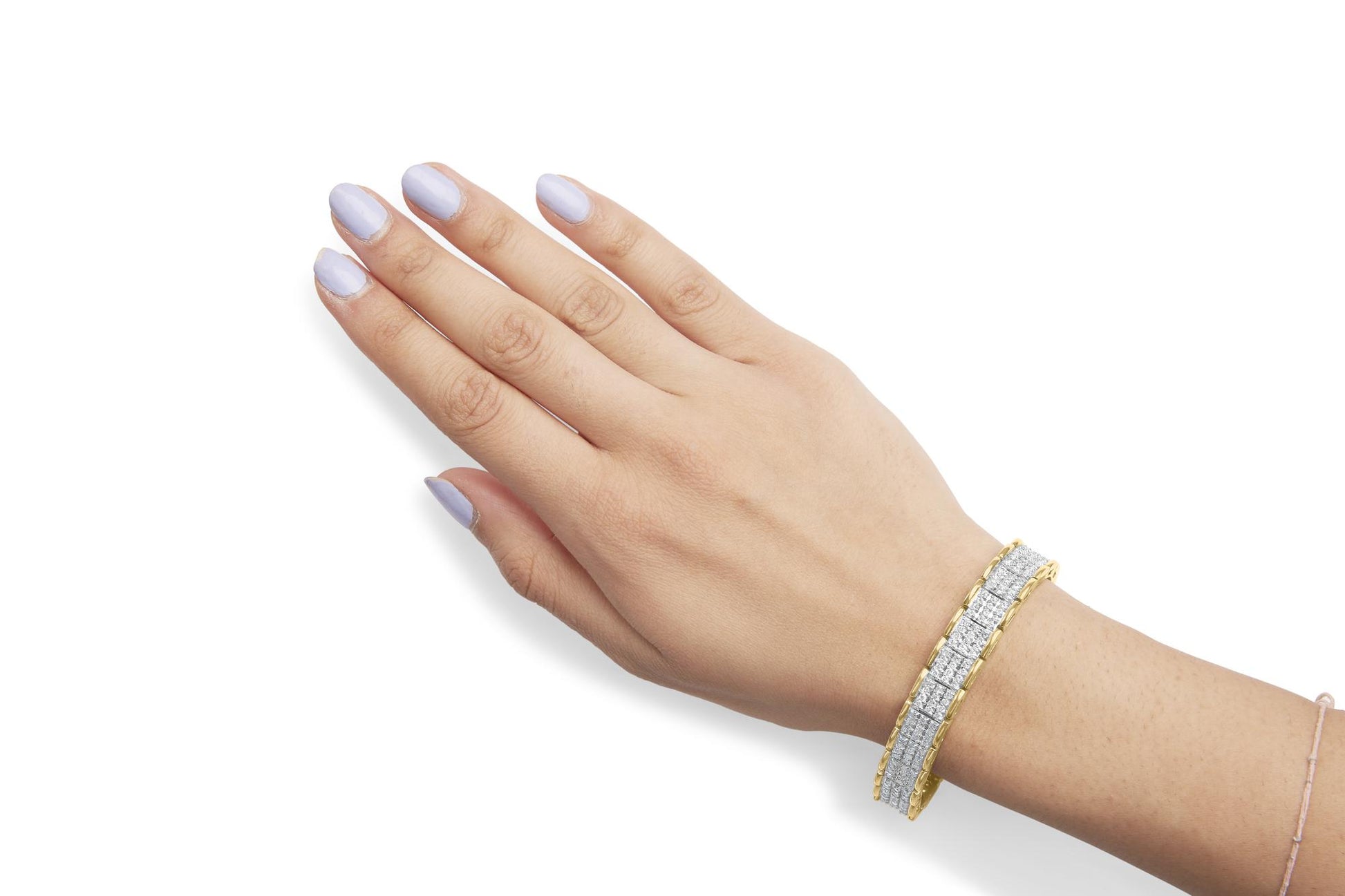 Close-up of a hand wearing a yellow metal bracelet with rows of white round gemstones in prong settings, shown from an angled top view.